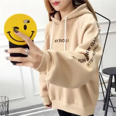 Casual beige hoodie with a drawstring, featuring text and a smiling face phone case.