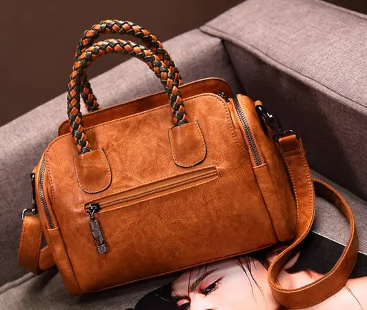 2019 retro stylish Boston bag in brown synthetic leather with braided handles and crossbody strap.