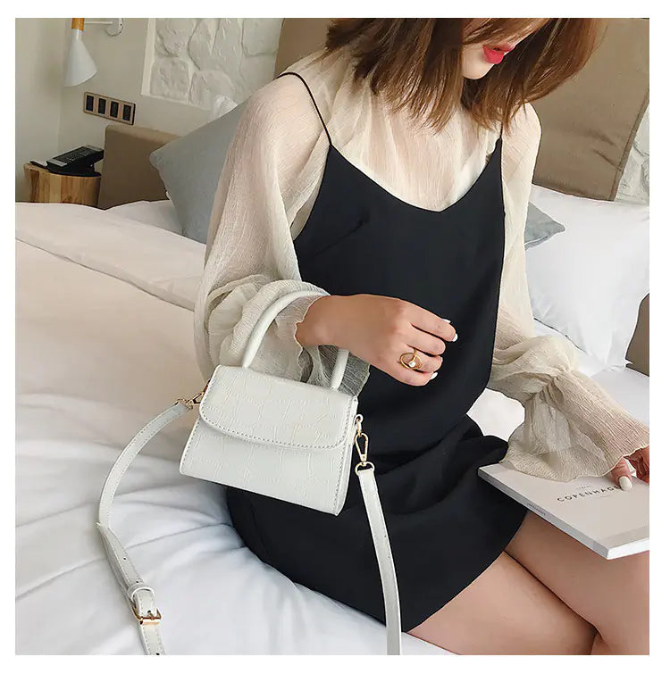 Chic mini stone pattern handbag worn with a black dress, showcasing a stylish crossbody bag perfect for any occasion.