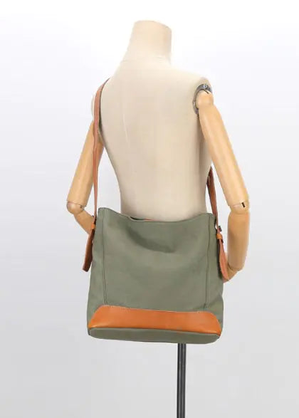 Versatile canvas shoulder and crossbody bag in olive green with tan accents, displayed on a mannequin.