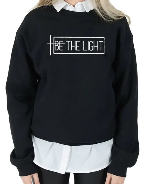 Black BE THE LIGHT sweatshirt with a bold printed design, perfect for stylish streetwear enthusiasts.