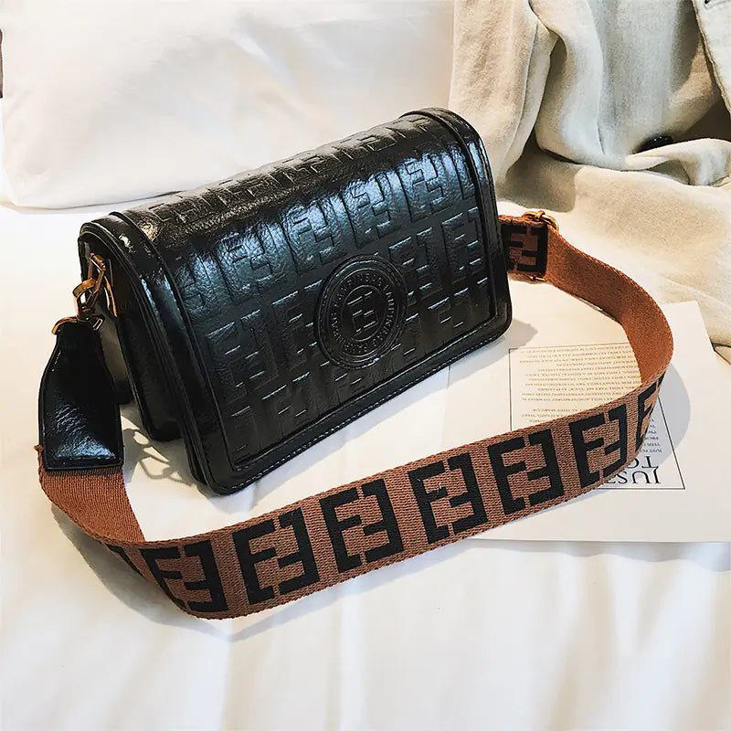 Vintage shoulder crossbody bag in black with logo strap, perfect for stylish everyday use.