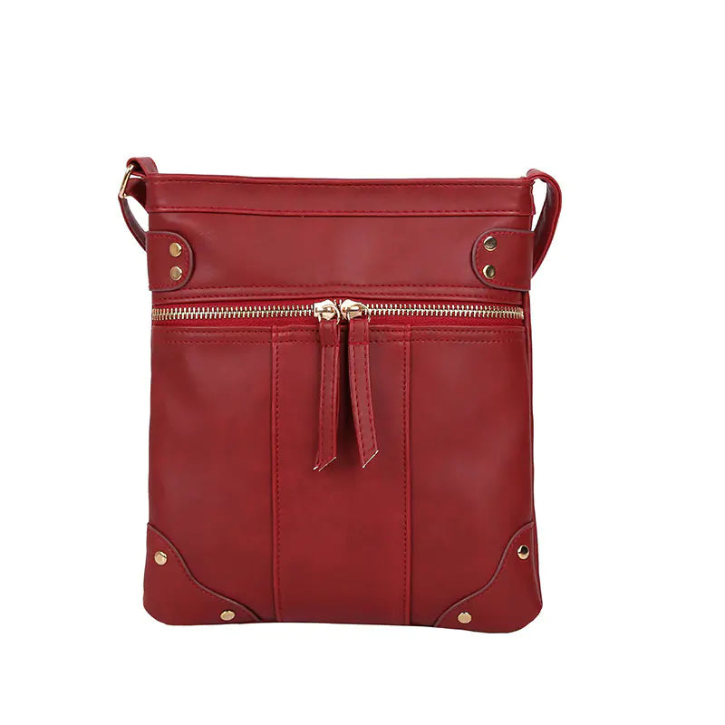 Vintage studded shoulder bag in red with gold zipper, stylish crossbody design for modern moms.