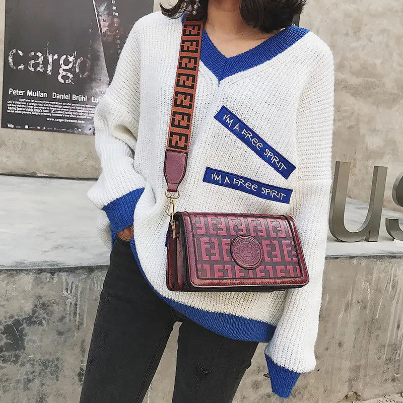 Vintage shoulder crossbody bag paired with a casual white and blue sweater, showcasing stylish retro fashion.