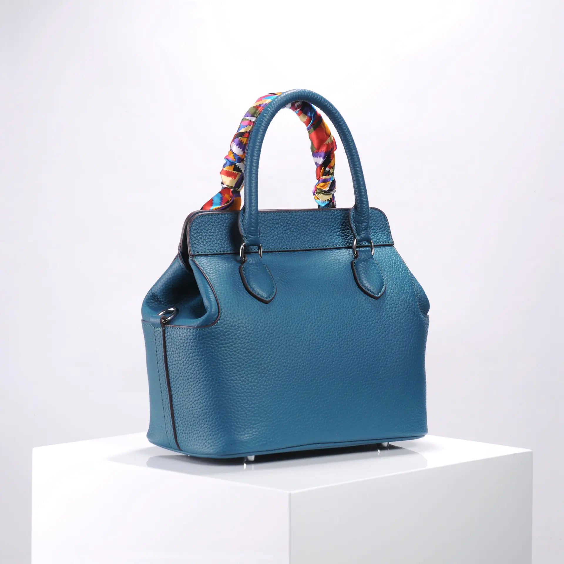 Stylish blue handbag with colorful patterned handles, perfect for elevating your fashion statement.