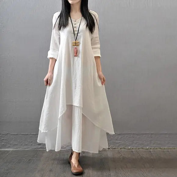 Model wearing a white two-piece long dress with loose sleeves, featuring a chic layered design and casual style.