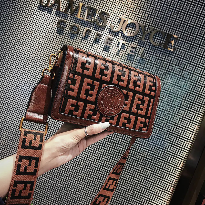 Chic vintage shoulder crossbody bag in rich brown with logo detail and stylish strap, ideal for everyday use.