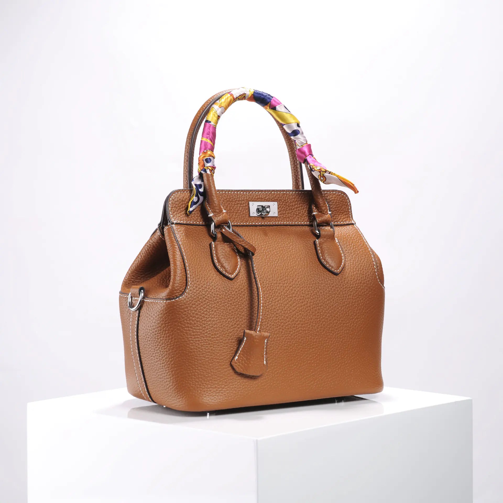 Stylish brown leather handbag with colorful handles, featuring a chic design for modern elegance.