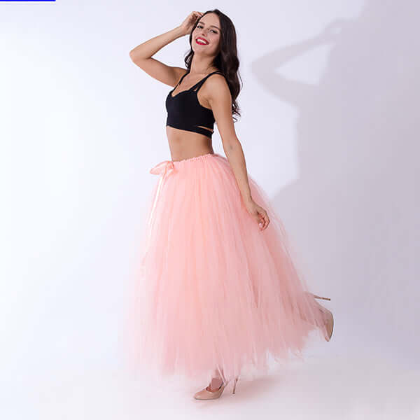 Pregnant woman dress featuring a flowing pink tulle skirt paired with a black top, perfect for maternity style.