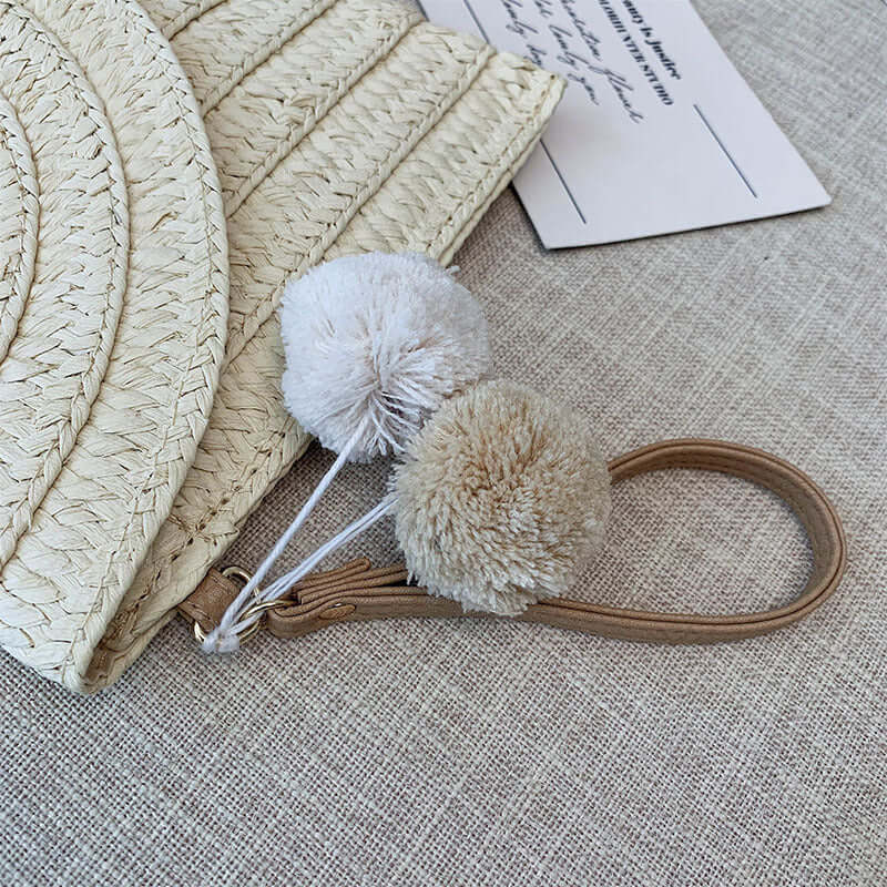 New style hand woven bags in summer featuring soft pom-pom accessories and textured design.