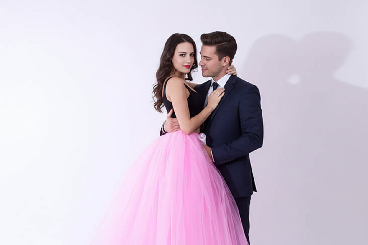 Pregnant woman dress in pink tulle with black top, featuring a ribbon belt, ideal for maternity occasions.
