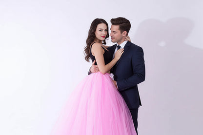 Pregnant woman dress in pink tulle with black top, featuring a ribbon belt, ideal for maternity occasions.