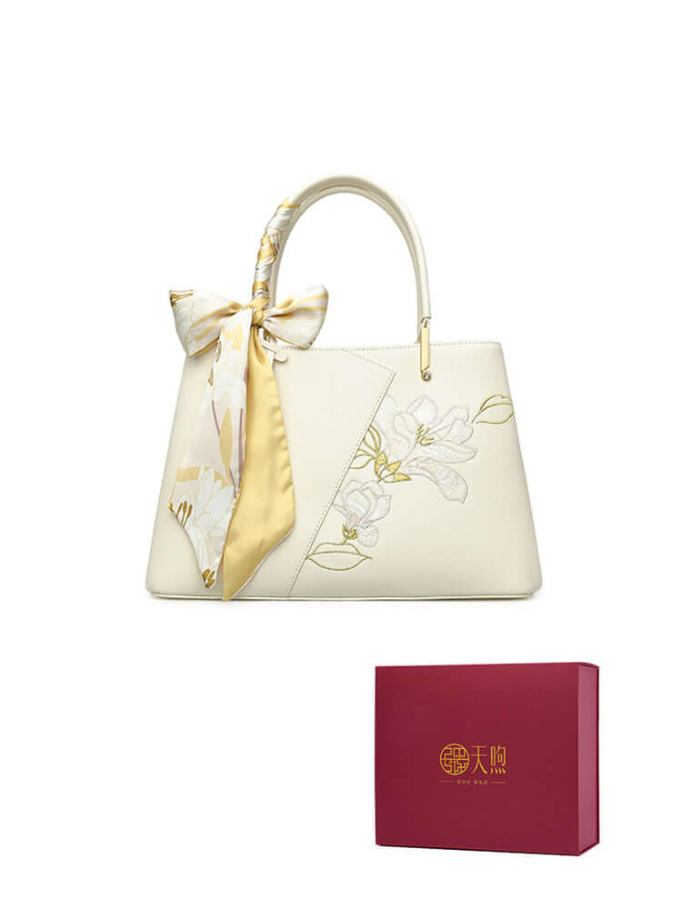 Pearl cowhide handbag with floral design and scarf, presented in elegant gift box.