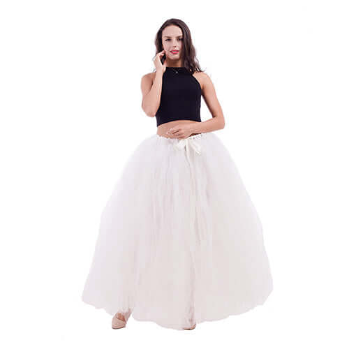 Pregnant woman dress displayed on a model, featuring a black top and a flowing white skirt.