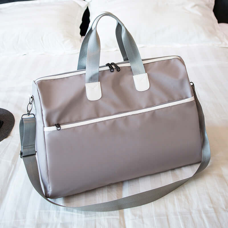 Hand-held large-capacity men's and women's body bags displayed on a bed, showcasing its large size and stylish design.