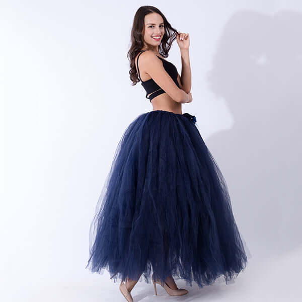 Pregnant woman dress model wearing a stylish navy tulle skirt and black top, showcasing elegant maternity fashion.