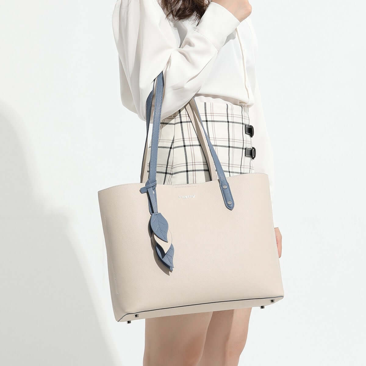 large capacity leather handbag displayed by a woman in a stylish outfit, showcasing minimalistic design and elegance.