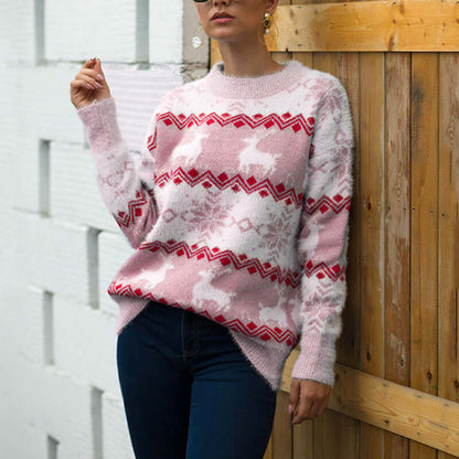 Snowflake deer pullover woman in pink sweater with deer design, styled casually against a wooden background.