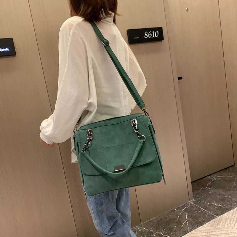 Woman carrying a large capacity matcha green shoulder bag, styled with a white top and casual jeans.