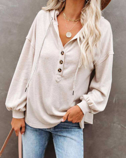 Autumn and Winter Solid Color Loose Hooded Woman wearing a beige hoodie with buttons and long sleeves.