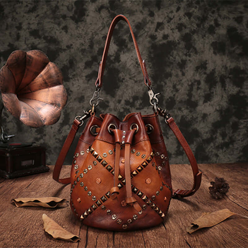 Cowhide Bucket Shoulder Bag With Rivet Detail on a wooden surface with vintage decor
