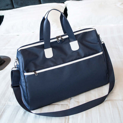 Hand-held large-capacity men's and women's body bags in navy blue color on a bed.
