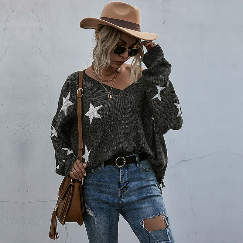 Tassel knitting sweater woman with star pattern, worn with jeans and a hat.