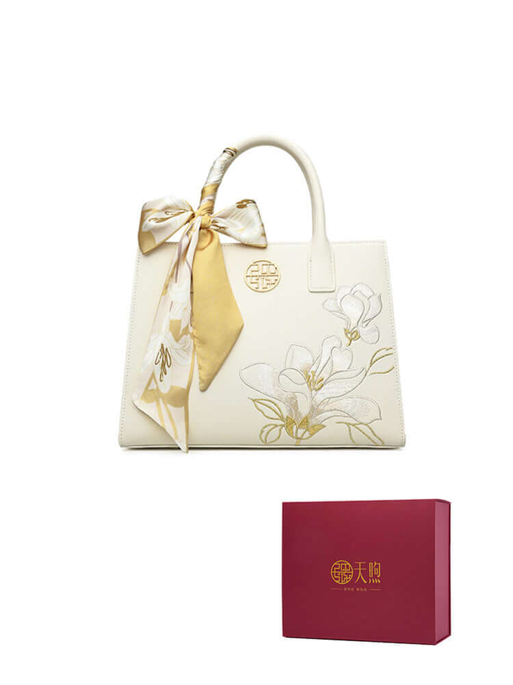 Pearl cowhide handbag with floral design and elegant silk scarf, presented in stylish gift box.