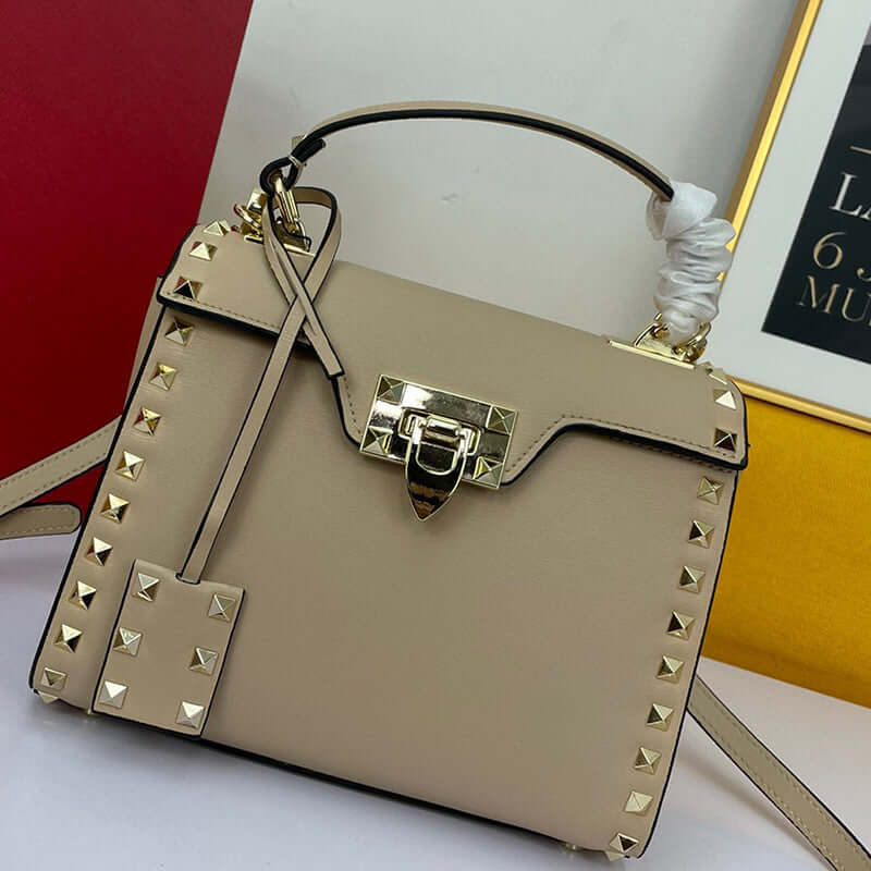 Cowhide Rivet-bound Women's Bag With Single-shoulder Messenger Pattern, featuring gold studs and lock closure.