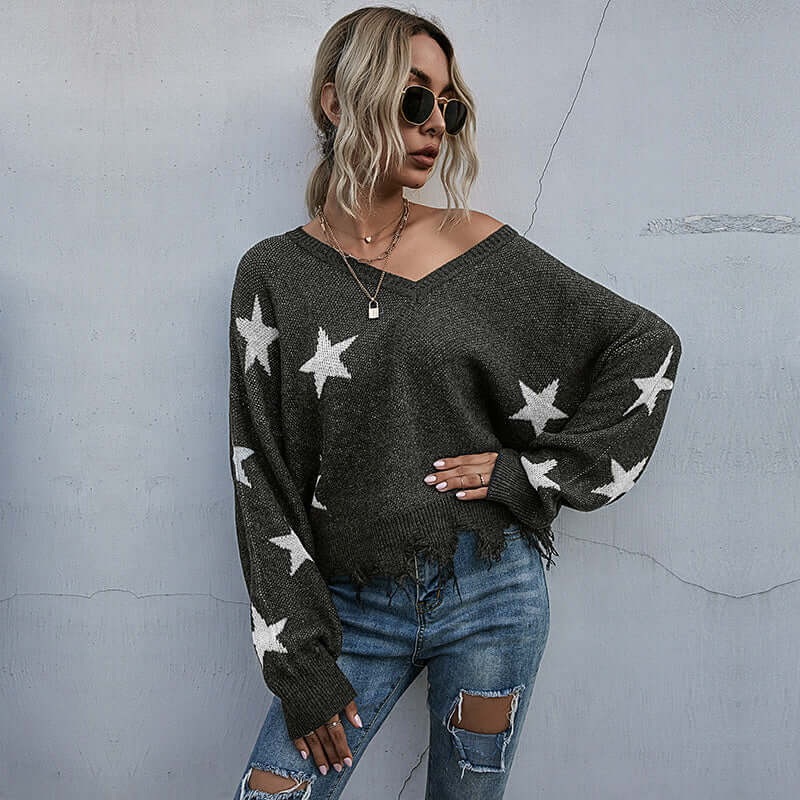 Tassel knitting sweater woman with star pattern in dark gray, styled with jeans and sunglasses.