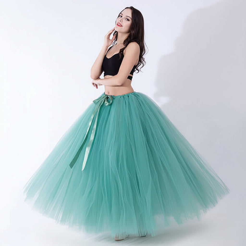 Pregnant woman dress in teal tulle skirt with a black top, stylish maternity outfit.