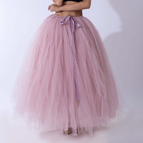 Pregnant woman dress with a flowing pink tulle skirt and ribbon, made from polyester fiber.