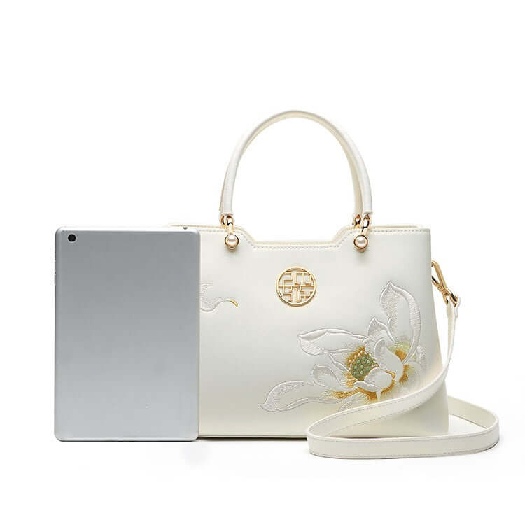Cowhide Floral Crossbody Shoulder Bag for Cheongsam next to a tablet, showcasing elegant floral design.