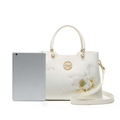 Cowhide Floral Crossbody Shoulder Bag for Cheongsam next to a tablet, showcasing elegant floral design.