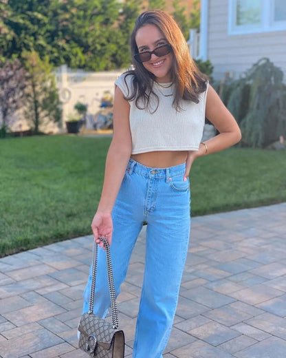 Knitwear top vest woman, cropped style, summer outfit, casual look, featuring light-colored top and light blue jeans.