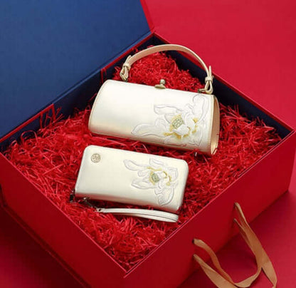 Pearl cowhide handbag elegantly packaged in a red gift box with floral accents.