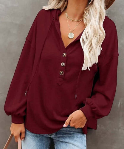 Autumn and Winter Solid Color Loose Hooded Woman in burgundy with buttons and long sleeves.