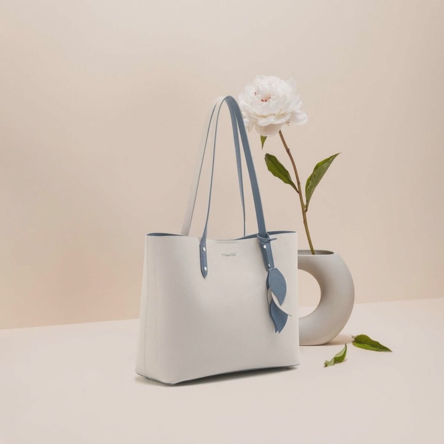 Women’s Leather Shell Handbag – Large Capacity Tote displayed with flower arrangement.